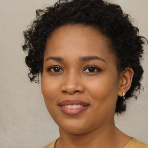 Joyful black young-adult female with short  brown hair and brown eyes