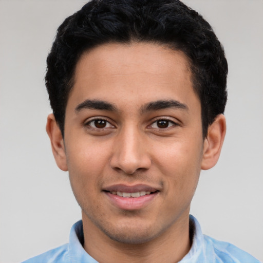 Joyful latino young-adult male with short  black hair and brown eyes