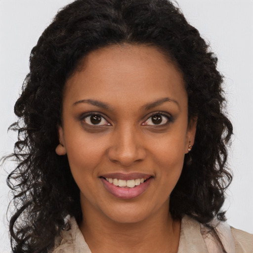 Joyful black young-adult female with long  brown hair and brown eyes