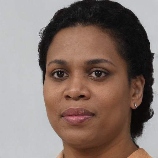 Joyful black young-adult female with short  black hair and brown eyes