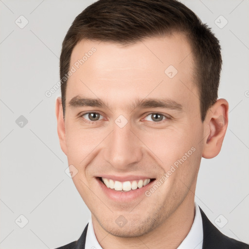 Joyful white young-adult male with short  brown hair and brown eyes