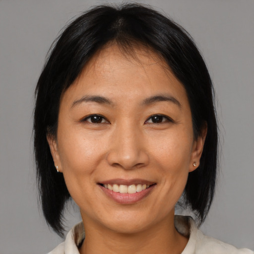 Joyful asian adult female with medium  brown hair and brown eyes