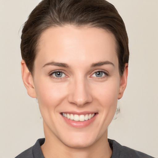 Joyful white young-adult female with short  brown hair and grey eyes