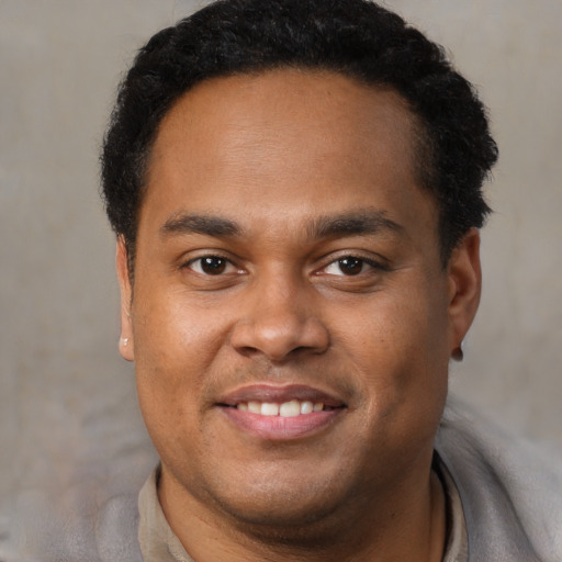 Joyful latino young-adult male with short  brown hair and brown eyes