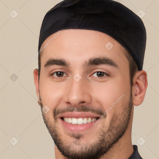 Joyful white young-adult male with short  black hair and brown eyes