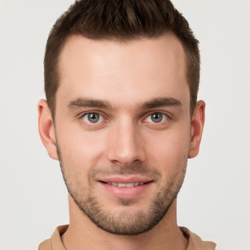 Joyful white young-adult male with short  brown hair and grey eyes