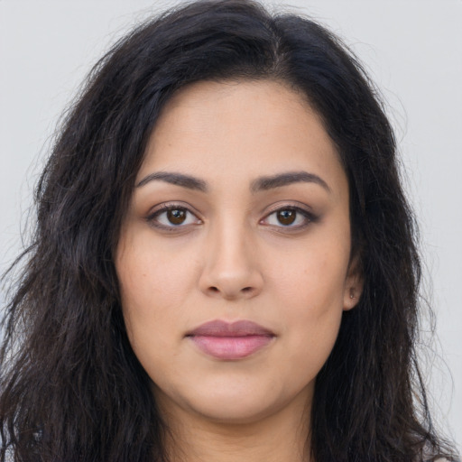 Joyful latino young-adult female with long  brown hair and brown eyes