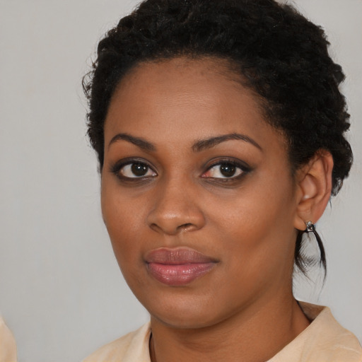 Joyful black young-adult female with long  brown hair and brown eyes