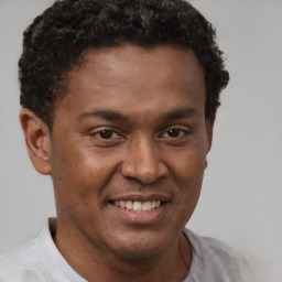 Joyful latino young-adult male with short  brown hair and brown eyes