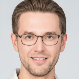 Joyful white young-adult male with short  brown hair and grey eyes