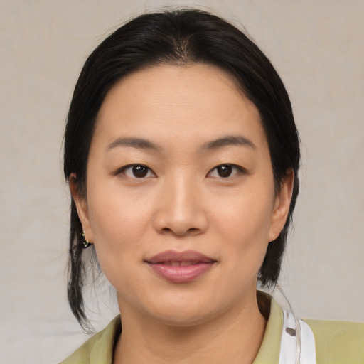 Joyful asian young-adult female with medium  black hair and brown eyes