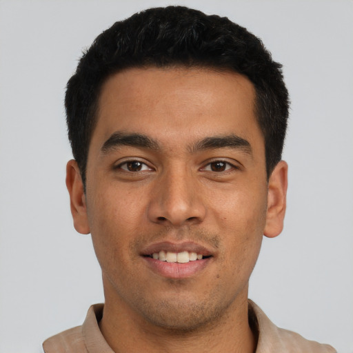 Joyful latino young-adult male with short  black hair and brown eyes