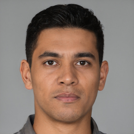Joyful latino young-adult male with short  brown hair and brown eyes