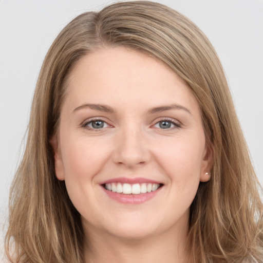 Joyful white young-adult female with long  brown hair and grey eyes