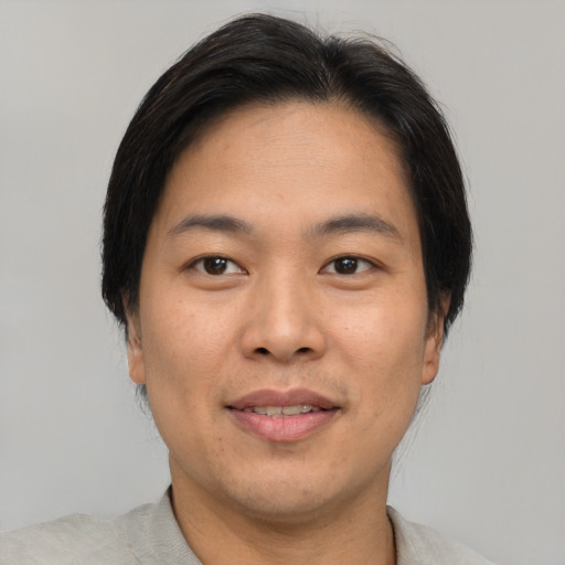 Joyful asian adult male with short  brown hair and brown eyes