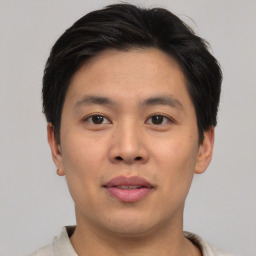 Joyful asian young-adult male with short  brown hair and brown eyes