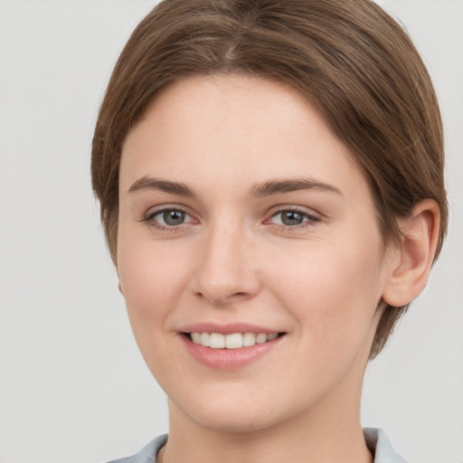 Joyful white young-adult female with short  brown hair and grey eyes