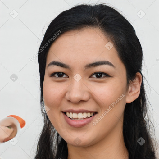 Joyful asian young-adult female with long  brown hair and brown eyes