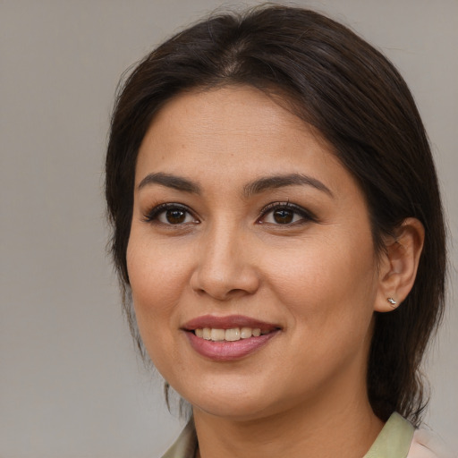 Joyful latino young-adult female with medium  brown hair and brown eyes