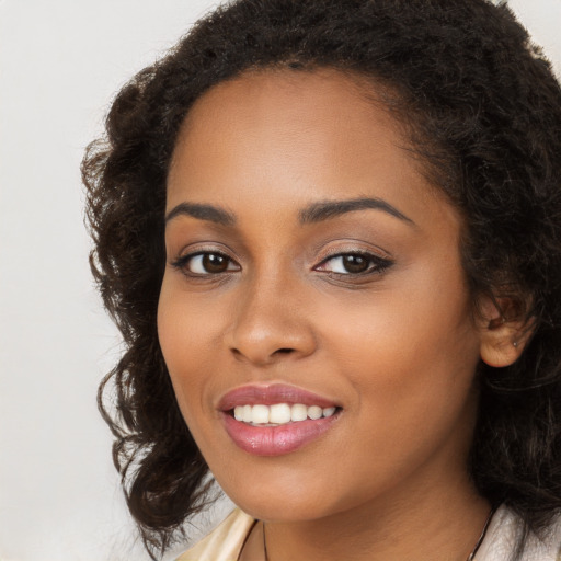 Joyful black young-adult female with long  brown hair and brown eyes