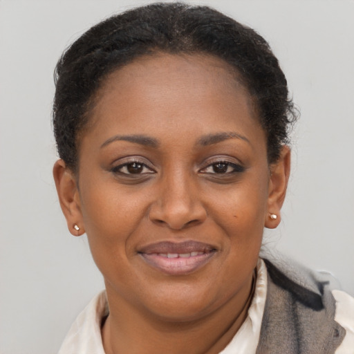 Joyful black adult female with short  brown hair and brown eyes