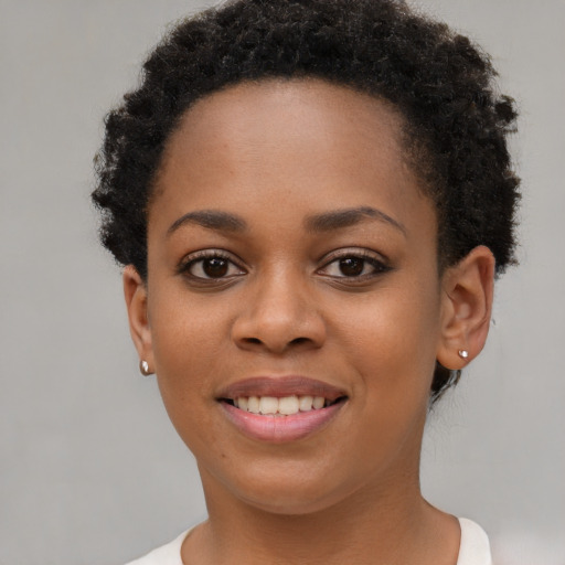 Joyful black young-adult female with short  brown hair and brown eyes