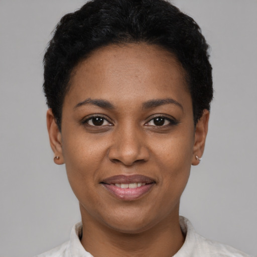 Joyful black young-adult female with short  black hair and brown eyes