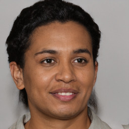 Joyful latino adult female with short  brown hair and brown eyes