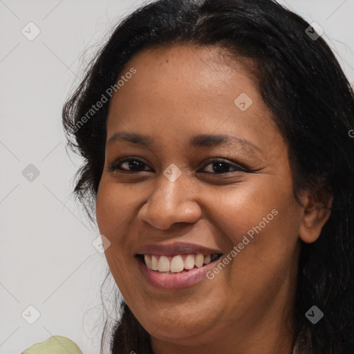 Joyful black young-adult female with long  brown hair and brown eyes