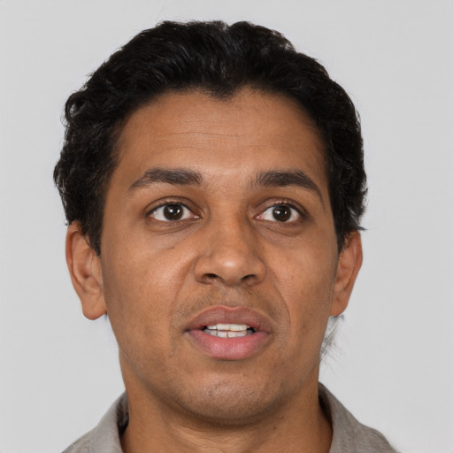 Joyful latino adult male with short  brown hair and brown eyes