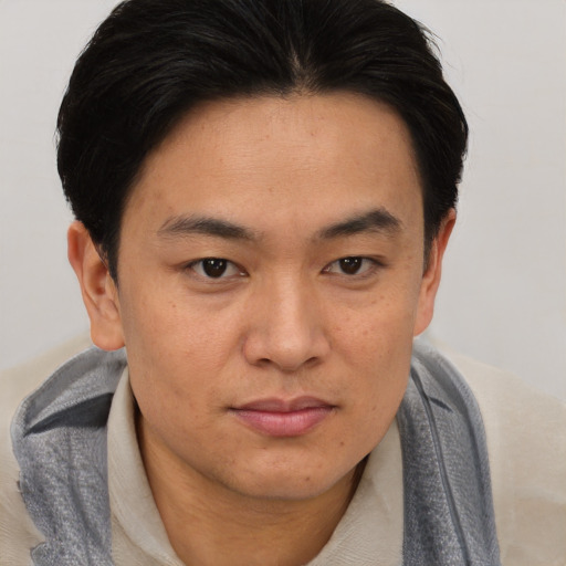 Joyful asian young-adult male with short  brown hair and brown eyes