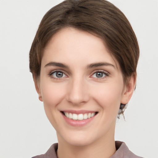 Joyful white young-adult female with short  brown hair and grey eyes