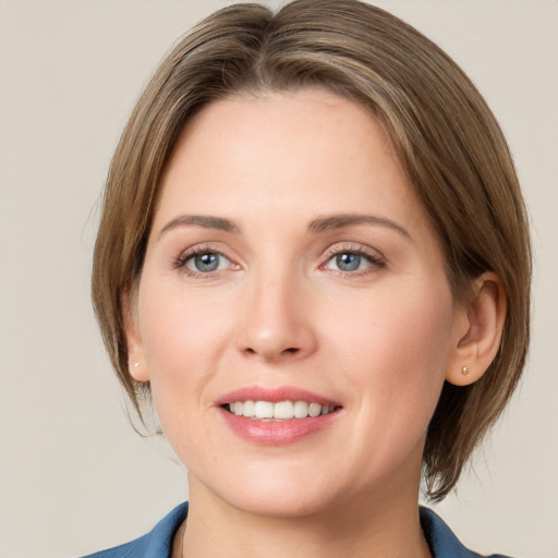 Joyful white young-adult female with medium  brown hair and grey eyes