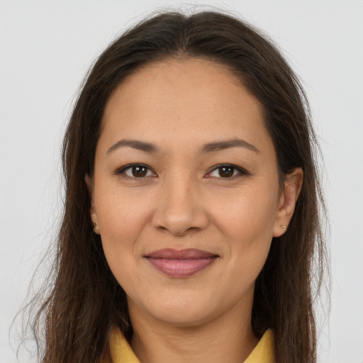 Joyful latino adult female with long  brown hair and brown eyes