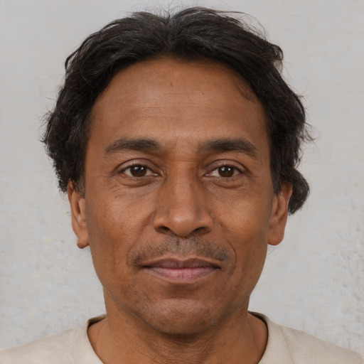 Joyful latino adult male with short  brown hair and brown eyes