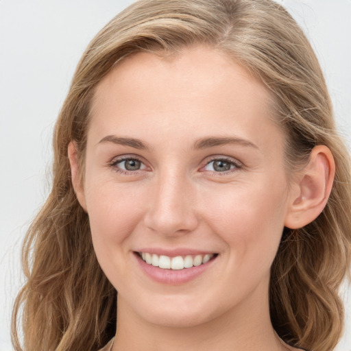 Joyful white young-adult female with long  brown hair and blue eyes