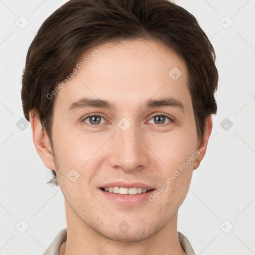 Joyful white young-adult male with short  brown hair and grey eyes