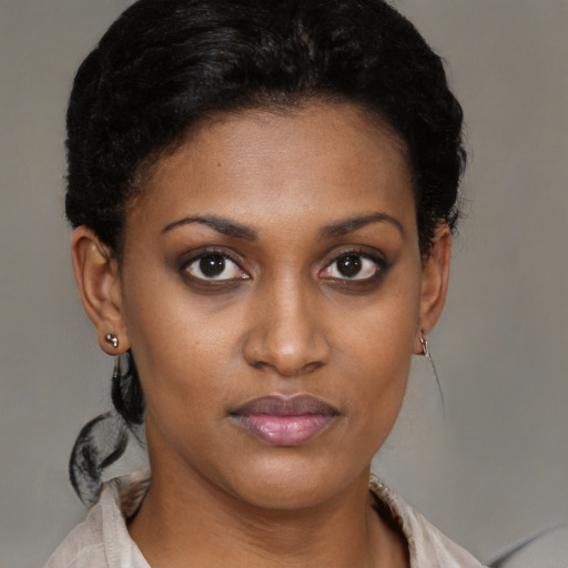Joyful black young-adult female with short  brown hair and brown eyes
