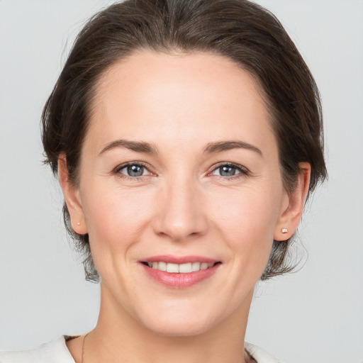 Joyful white adult female with medium  brown hair and brown eyes