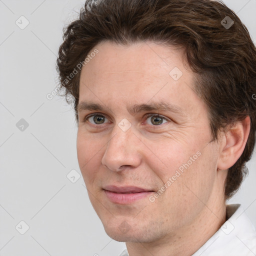 Joyful white adult male with short  brown hair and grey eyes