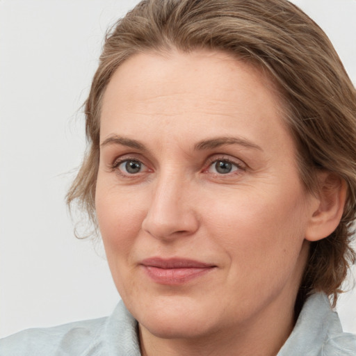 Joyful white adult female with medium  brown hair and blue eyes