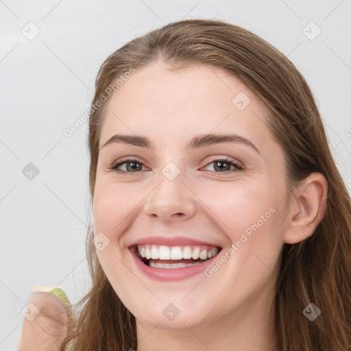 Joyful white young-adult female with long  brown hair and blue eyes