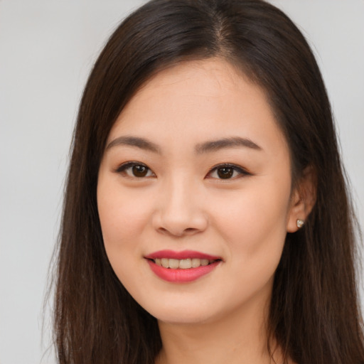 Joyful asian young-adult female with long  brown hair and brown eyes