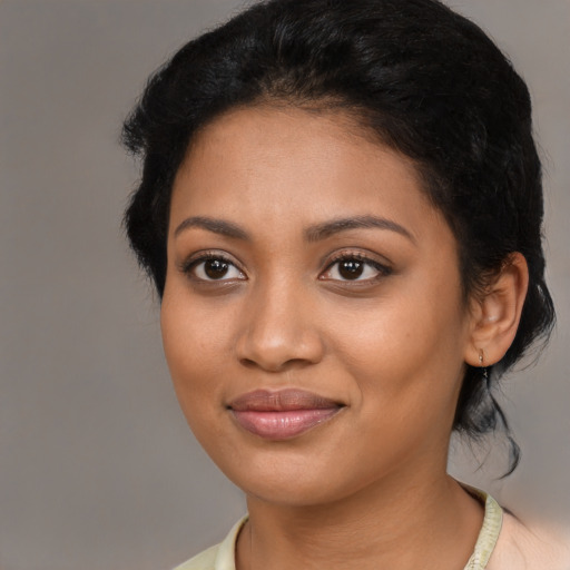 Joyful black young-adult female with medium  black hair and brown eyes