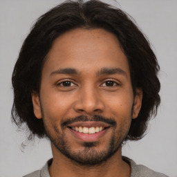 Joyful latino young-adult male with short  brown hair and brown eyes