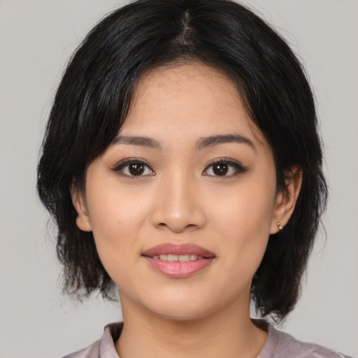 Joyful asian young-adult female with medium  black hair and brown eyes