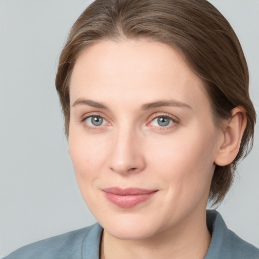 Joyful white young-adult female with medium  brown hair and blue eyes