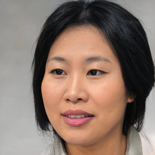 Joyful asian young-adult female with medium  black hair and brown eyes