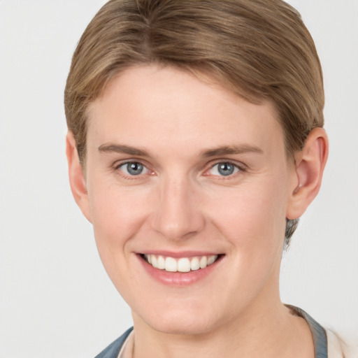 Joyful white young-adult female with short  brown hair and grey eyes