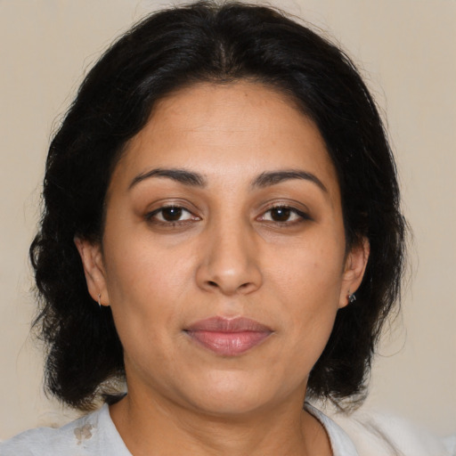 Joyful latino adult female with medium  brown hair and brown eyes